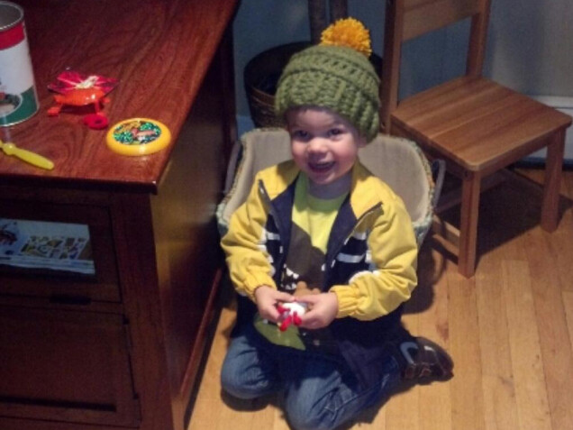 Detailed image 1 of green hat with yellow pompom